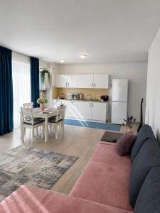 a living room with a couch and a table and a kitchen at Fly Airport Residences & Therme-SELF CHECK-IN in Otopeni