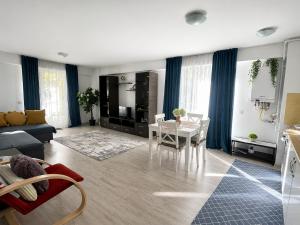 a living room with a table and a dining room at Fly Airport Residences & Therme-SELF CHECK-IN in Otopeni