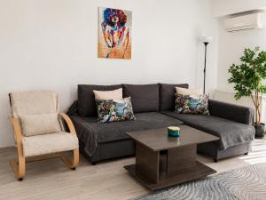 a living room with a couch and a chair at Fly Airport Residences & Therme-SELF CHECK-IN in Otopeni