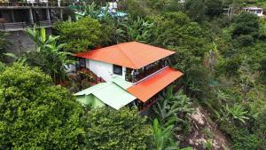 an orange roofed house on top of a hill at KarSa Woods, Kodaikanal in Perumālmalai