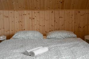 a bedroom with a bed with two towels on it at Lobeliowe Domki in Chośnica