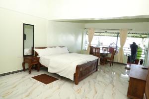 a bedroom with a bed and a person standing in the window at KarSa Woods, Kodaikanal in Perumālmalai