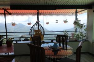 a dining room table with a view of the mountains at KarSa Woods, Kodaikanal in Perumālmalai