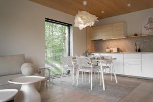 a kitchen and dining room with a table and chairs at Lobeliowe Domki in Chośnica