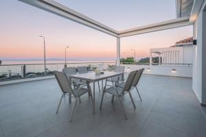 a dining room with a table and chairs on a balcony at Sunrise suites in Kallithea Halkidikis
