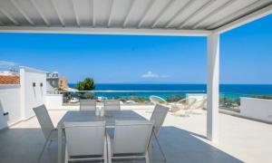a dining room with a view of the ocean at Sunrise suites in Kallithea Halkidikis