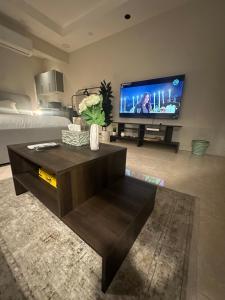 a living room with a large flat screen tv at Clarance studio in Dhahran