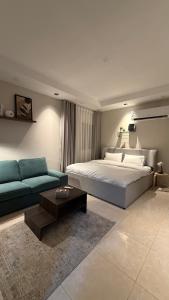 a large bedroom with a bed and a couch at Clarance studio in Dhahran