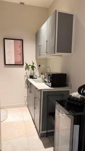a small kitchen with a sink and a microwave at Clarance studio in Dhahran