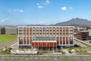 a large office building with mountains in the background at Beijing Marriott Hotel Huairou in Huairou