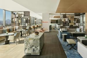 a lobby of a hotel with tables and chairs at Beijing Marriott Hotel Huairou in Huairou