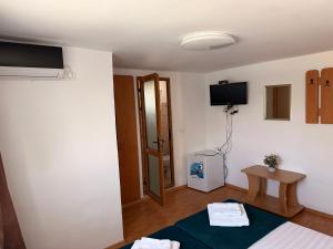 a room with a room with a bed and a tv at Vis de VARA in Băltenii de Sus