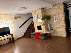 a living room with a staircase and a tv at Vis de VARA in Băltenii de Sus +57 photos