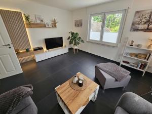 a living room with a table and a tv at Ferienwohnung Elya Gartenparadies nahe Events, Outlet und Spa in Bad Münstereifel