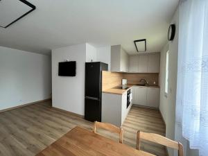 a kitchen with a black refrigerator and a table at Apartament przy plaży in Zbąszyń