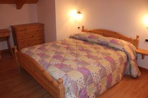 a bedroom with a bed with a quilt on it at Casa Monego in Fusine