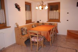 a dining room with a wooden table and chairs at Casa Monego in Fusine +1 photo