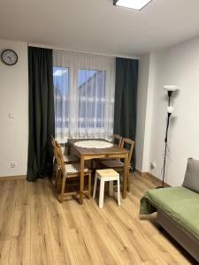 a dining room with a table and chairs and a window at Apartament przy plaży in Zbąszyń +8 photos