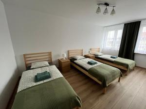 a room with three beds in a room at Apartament przy plaży in Zbąszyń