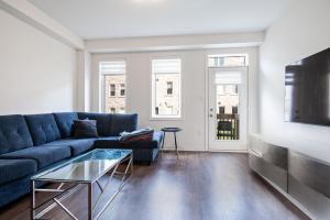 a living room with a blue couch and a tv at Modern Luxury Townhouse in Cambridge