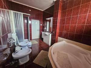 a bathroom with a tub and a toilet and a sink at Party Vendégház in Hajdúszoboszló +11 photos