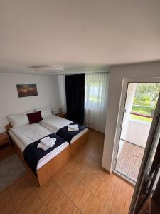 a bedroom with a bed and a large window at Vis de VARA in Băltenii de Sus