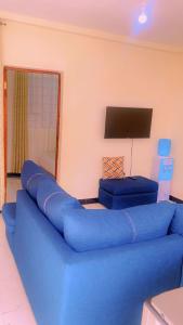 a blue couch in a living room with a tv at Moh airbnbs in Kisumu