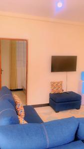 a living room with a blue couch and a flat screen tv at Moh airbnbs in Kisumu +17 photos