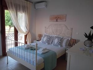 a bedroom with a bed and a large window at Κτήμα Verde in Agia Paraskevi