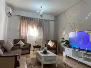 a living room with a large flat screen tv at Appartement F3 équipé lux in Skikda