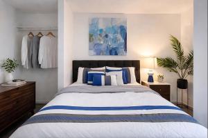 a bedroom with a bed with blue and white pillows at Remodeled, Spacious, Modern Retreat 5 BR, 3BA, 2KIT in Shoreline