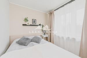 a bedroom with a white bed with two pillows at Sweet apartament in Haapsalu