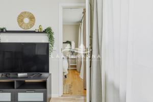 a living room with a television and a hallway at Sweet apartament in Haapsalu