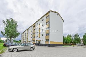 a car parked in a parking lot in front of a building at Sweet apartament in Haapsalu