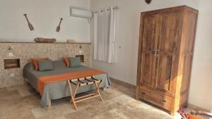 a bedroom with a bed and a wooden cabinet at Chez didine in Terre-de-Haut +9 photos