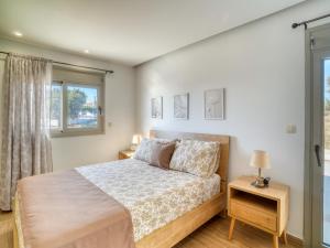 a bedroom with a bed and a window at Villa Elusia in Kefalos