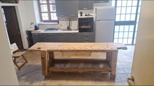a kitchen with a wooden table and a refrigerator at Mulimù - Guesthouse in Montecalvo Versiggia
