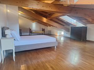 a large bedroom with a bed and wooden ceilings at Mulimù - Guesthouse in Montecalvo Versiggia
