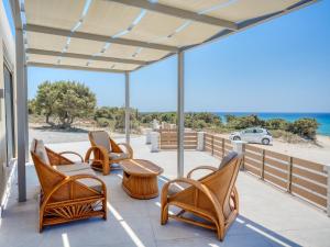 a patio with chairs and a table and a view of the beach at Villa Elusia in Kefalos