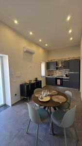 a living room with a table and chairs and a kitchen at Casa Vacanza Palazzo Monacelli 1 in Torre del Greco