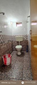 a bathroom with a toilet and a bucket in it at S K S HOME STAYs in Vālpārai