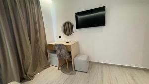 a room with a desk and a television on a wall at Villa e Diellit in Kaninë