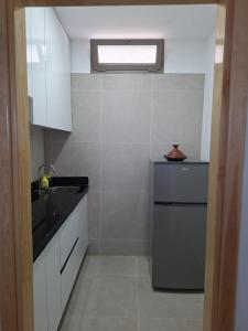 a small kitchen with a sink and a refrigerator at Suite Ania in Imejoudene +3 photos