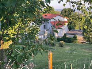 a white house in a yard with a fence at La Promesse by Hillis in Marennes