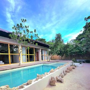 a swimming pool in front of a house at Wadi Residence in General Luna