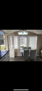 a kitchen and dining room with a table and chairs at Craig Tara Beach Lodge in Ayr