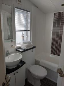 a white bathroom with a sink and a toilet at Craig Tara Beach Lodge in Ayr