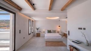 a bedroom with a white bed and a large window at The Lofts Paros Executive Suites in Naousa +92 photos