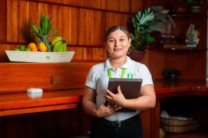 a woman standing in front of a counter holding a clipboard at Los Gavilanes Hotel in Pucallpa +82 photos