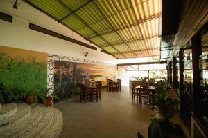 a restaurant with tables and chairs and a painting on the wall at Los Gavilanes Hotel in Pucallpa